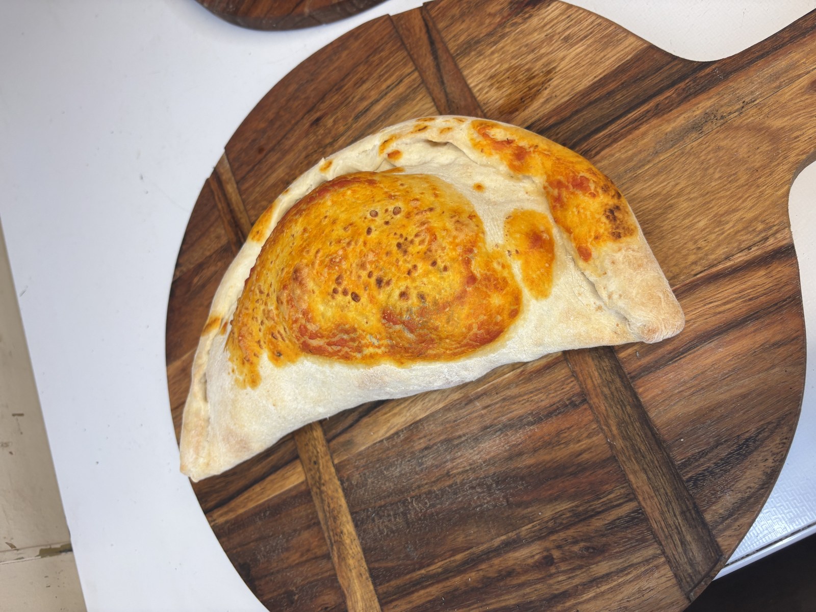 Calzoncini pizza pocket on wooden board